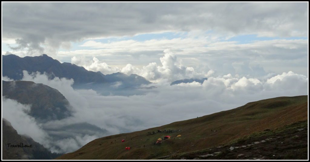 Clouds drift in from below from a valley