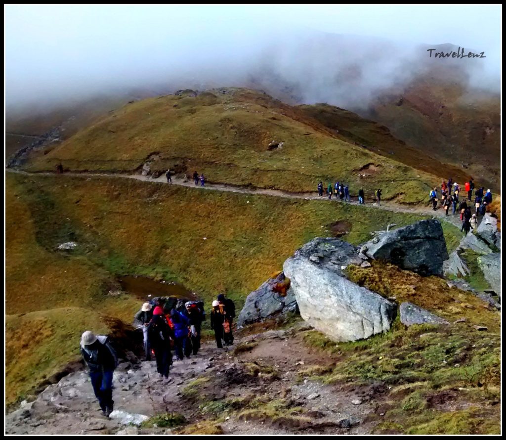 Trekkers climb up a steep mountain trail from Pathar Nachauni to Bhagwabasa