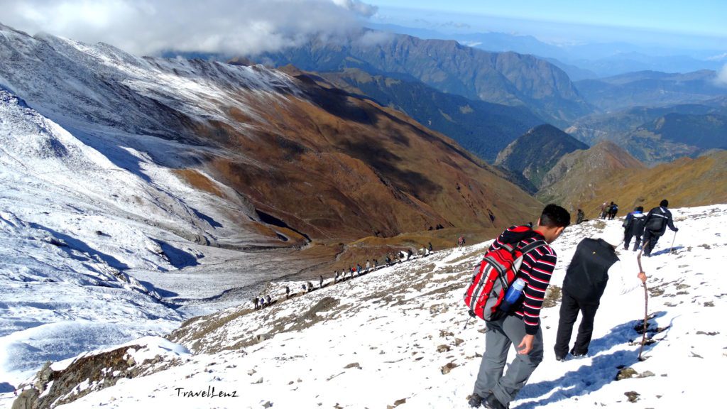 Trekkers hiking down a snowy mountain