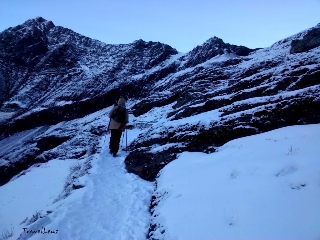 A trekker walks along a snowy path