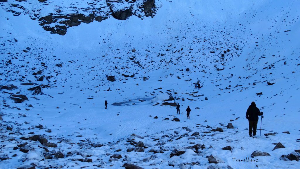 Trekkers walking down to a frozen lake