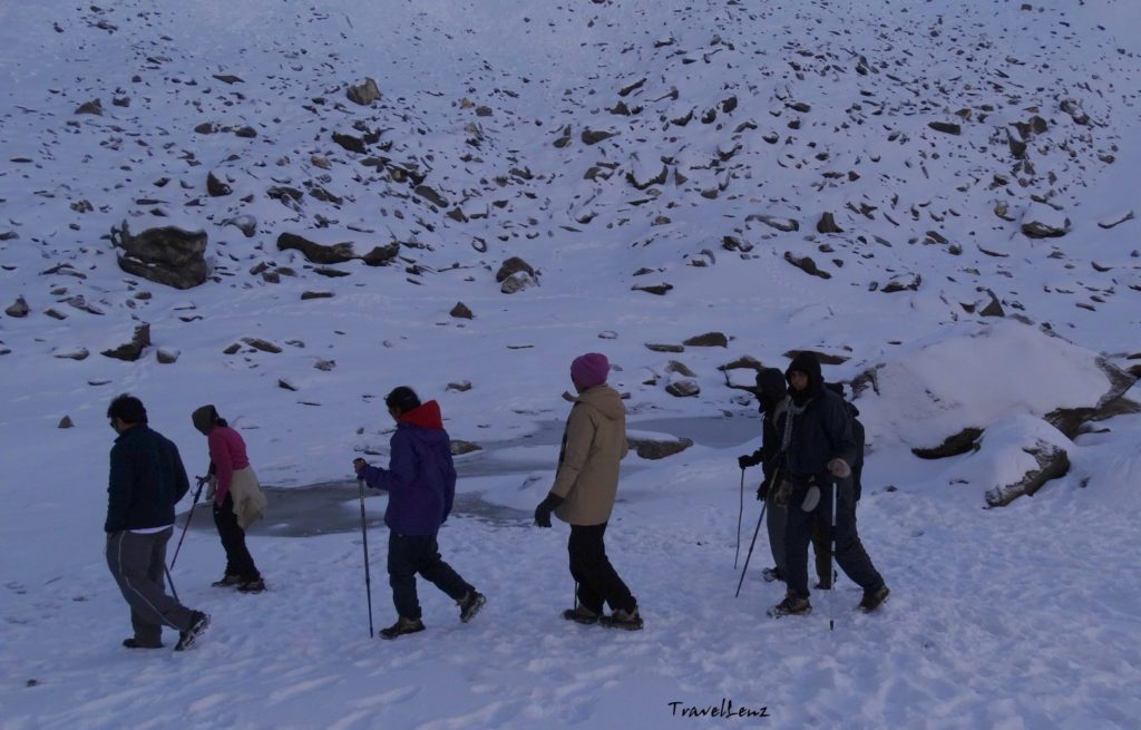 Trekkers walking around a frozen lake