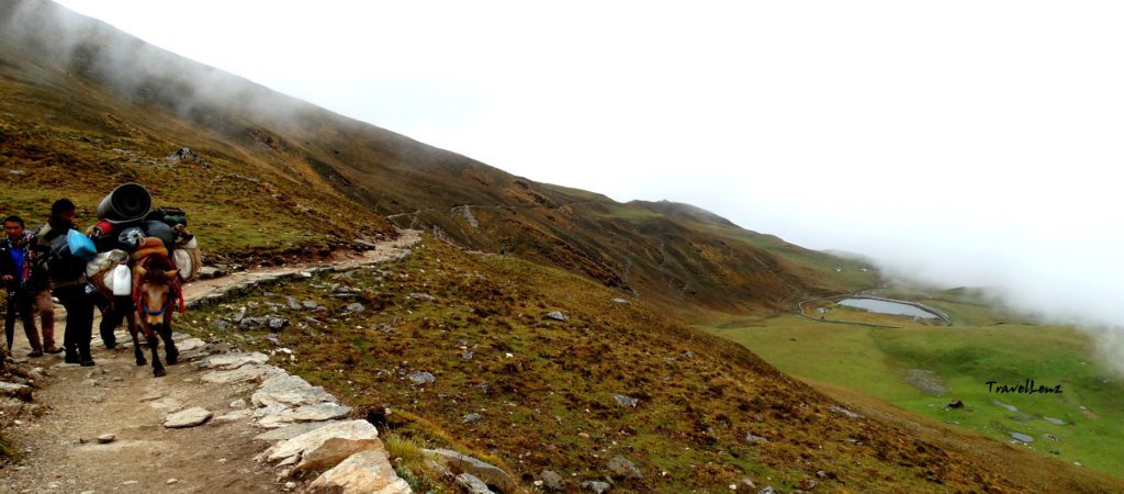 Trekkers cut across a mountain trail midway between Pathar Nachani and Lohajung