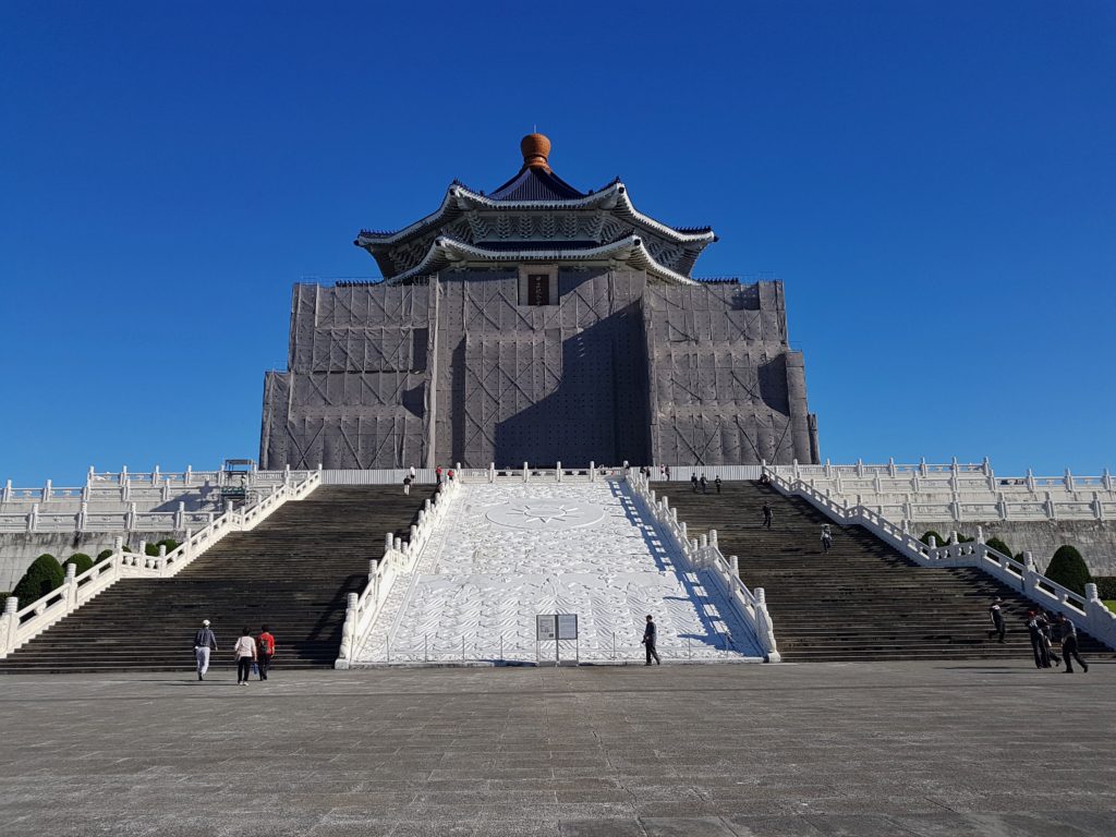 A memorial building with stairs leading up and blue sky behind