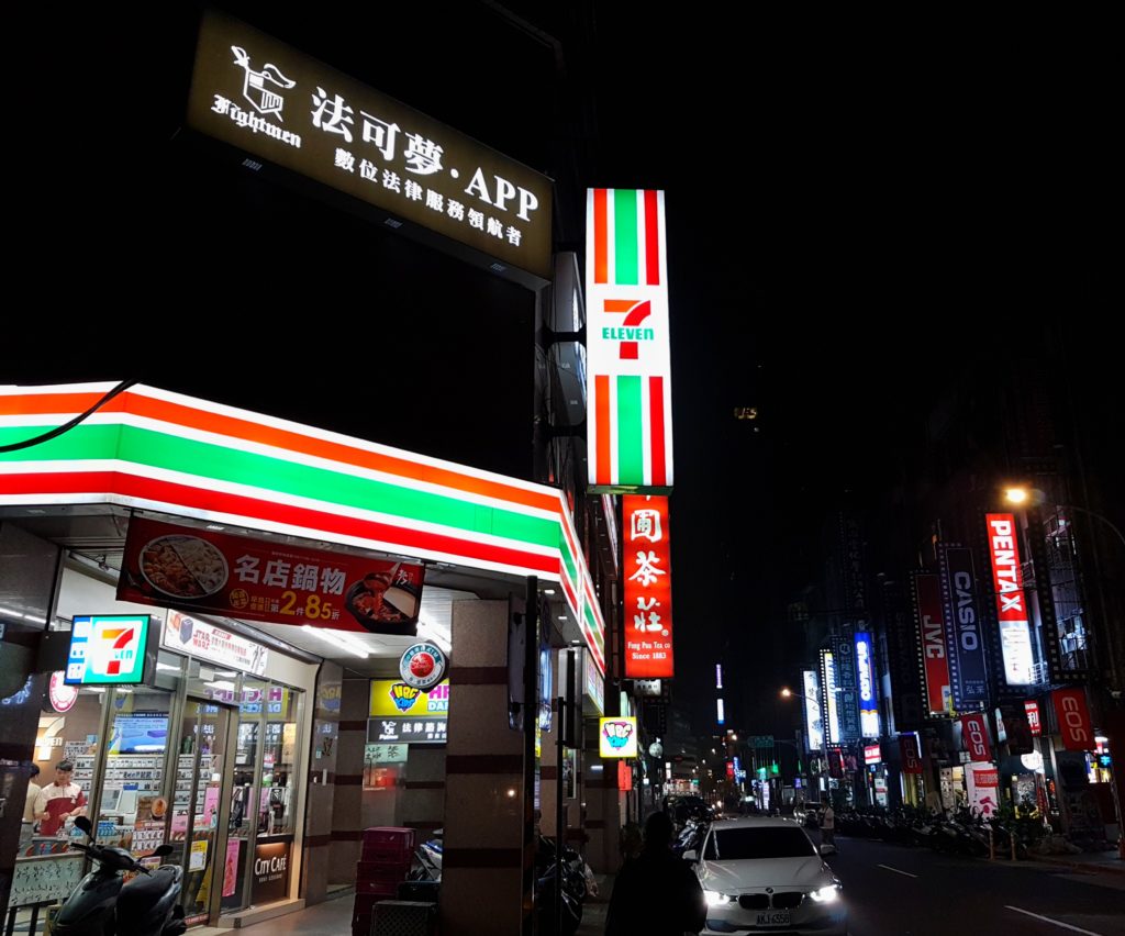 Store front in a market with neon signs and traffic