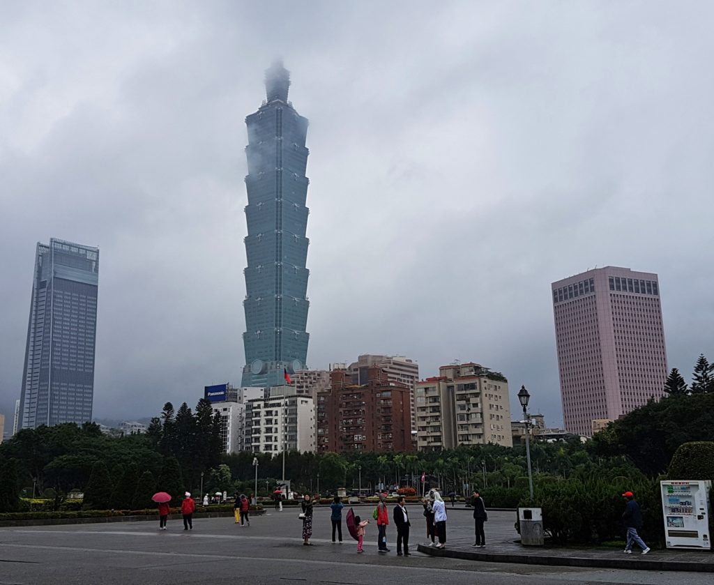 Visitors watching tall skyscrapers on a cloudy day