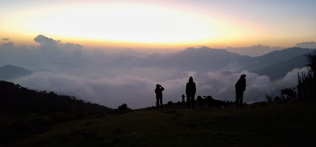 Trekkers looking into a valley of clouds