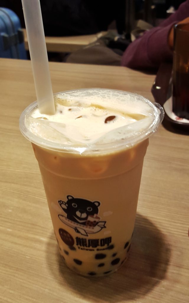 A plastic glass with milk shake inside and a straw sticking out