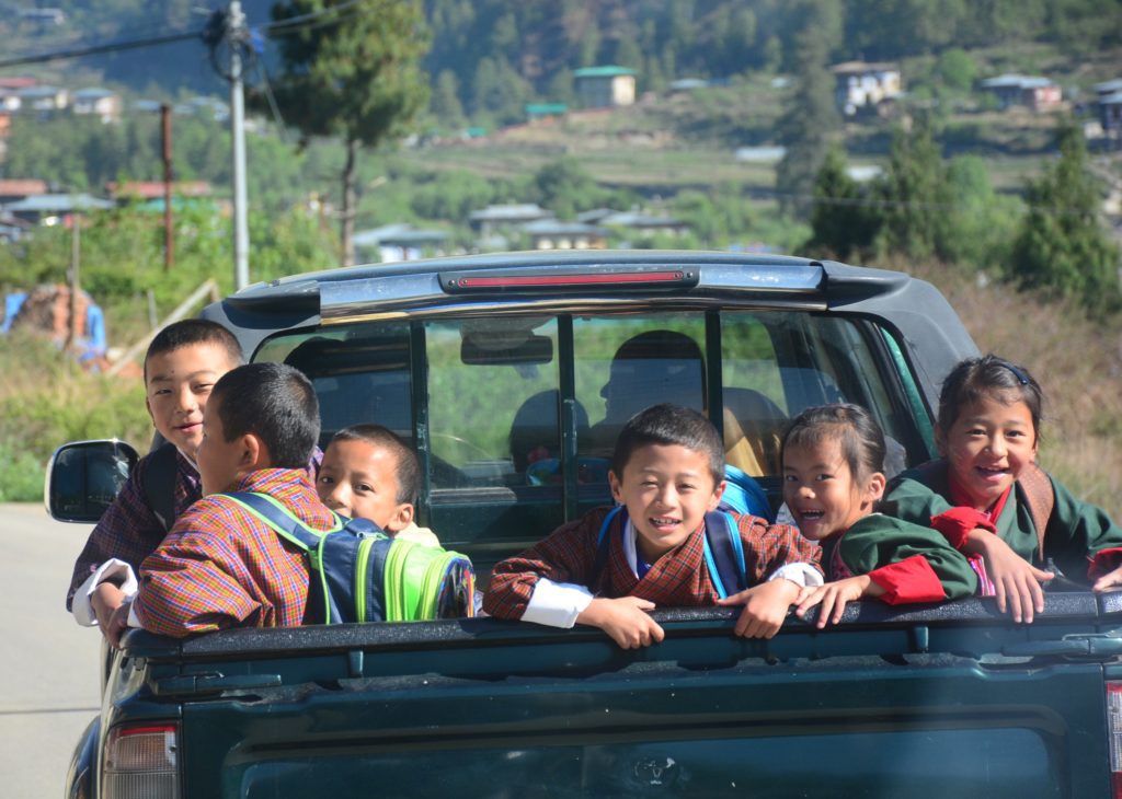 Smiling, joyful children in the back of a van on the road