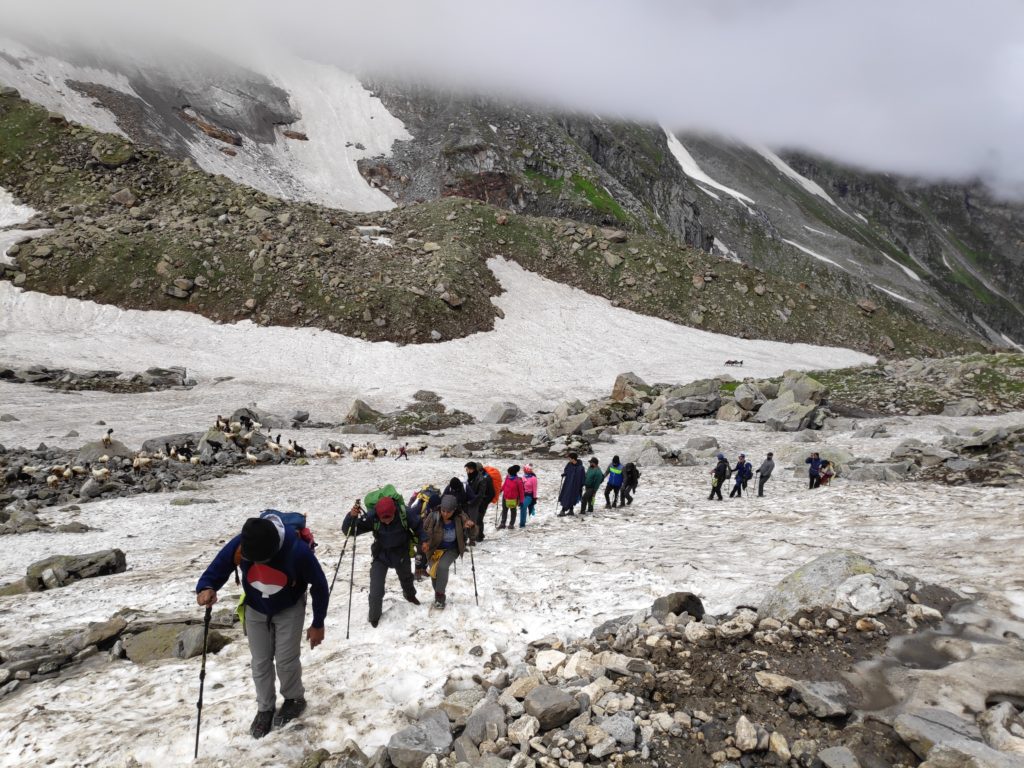 Trekkers climbing up a snowclad mountain trail